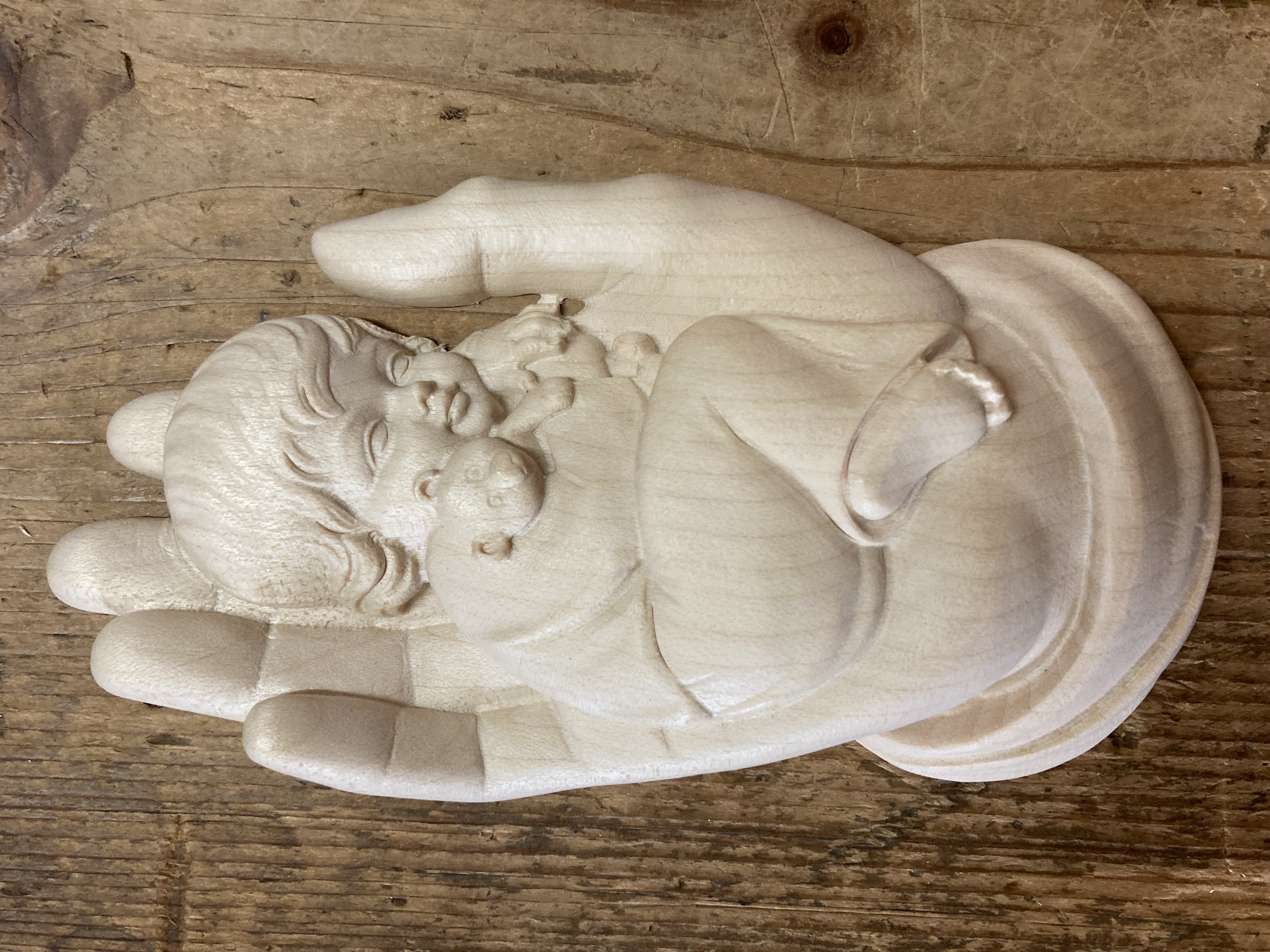 Relief Kind in Gottes Hand, aus Holz geschnitzt