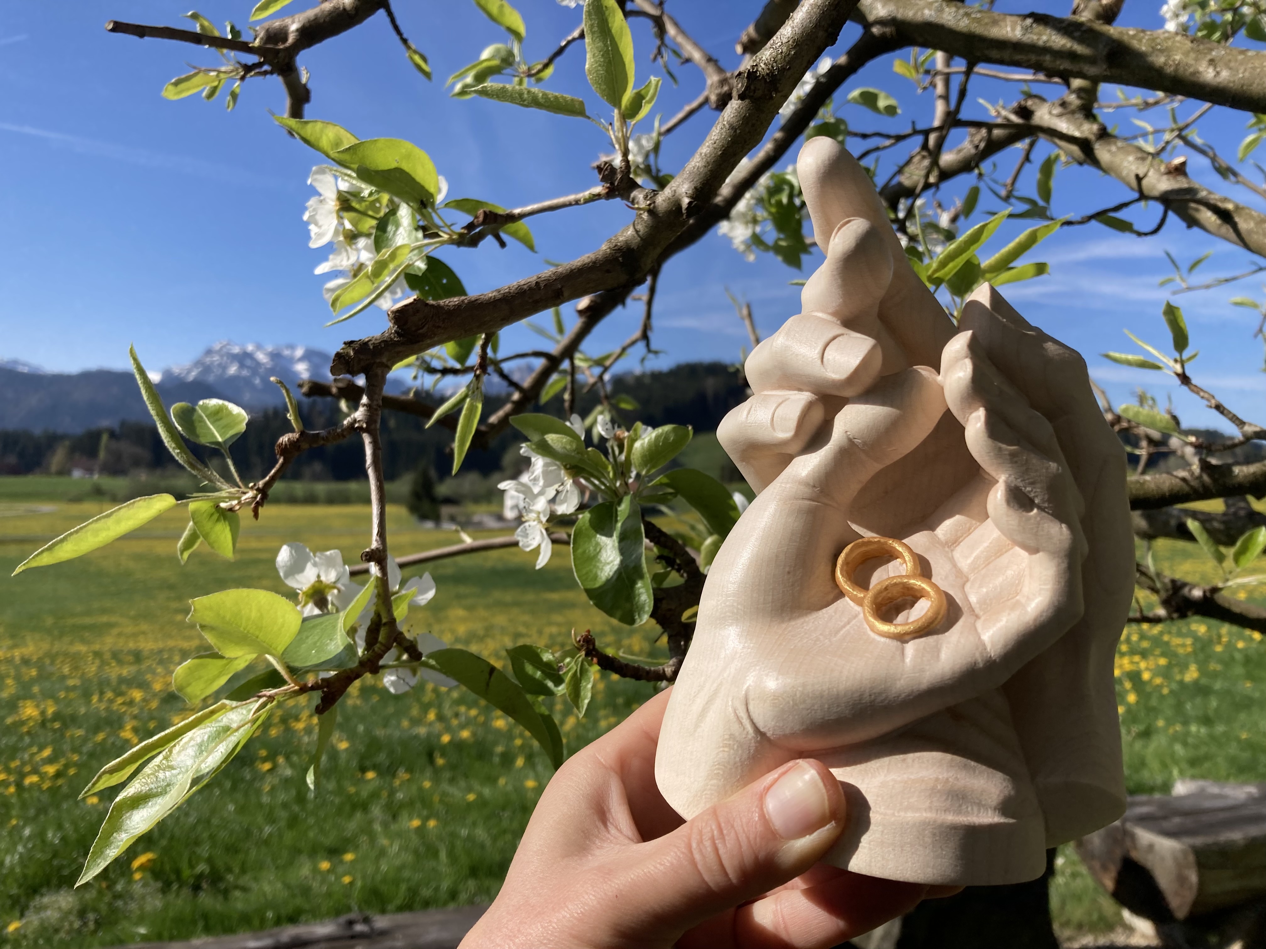 Geborgenheit der Ehe, geschnitzte Hände mit Ringen aus Holz