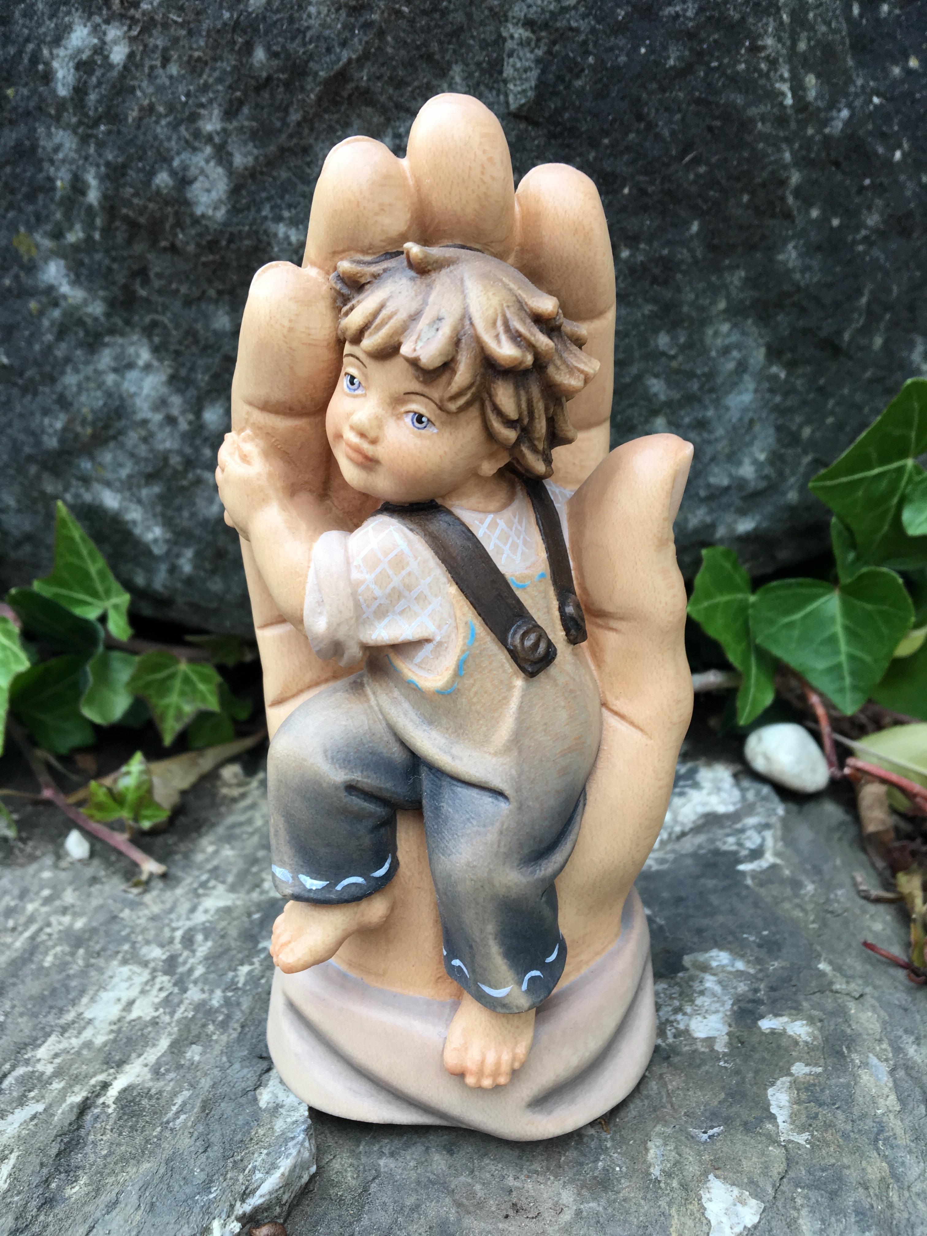 Kind in Gottes Hand aus Holz geschnitzt (Bub)
